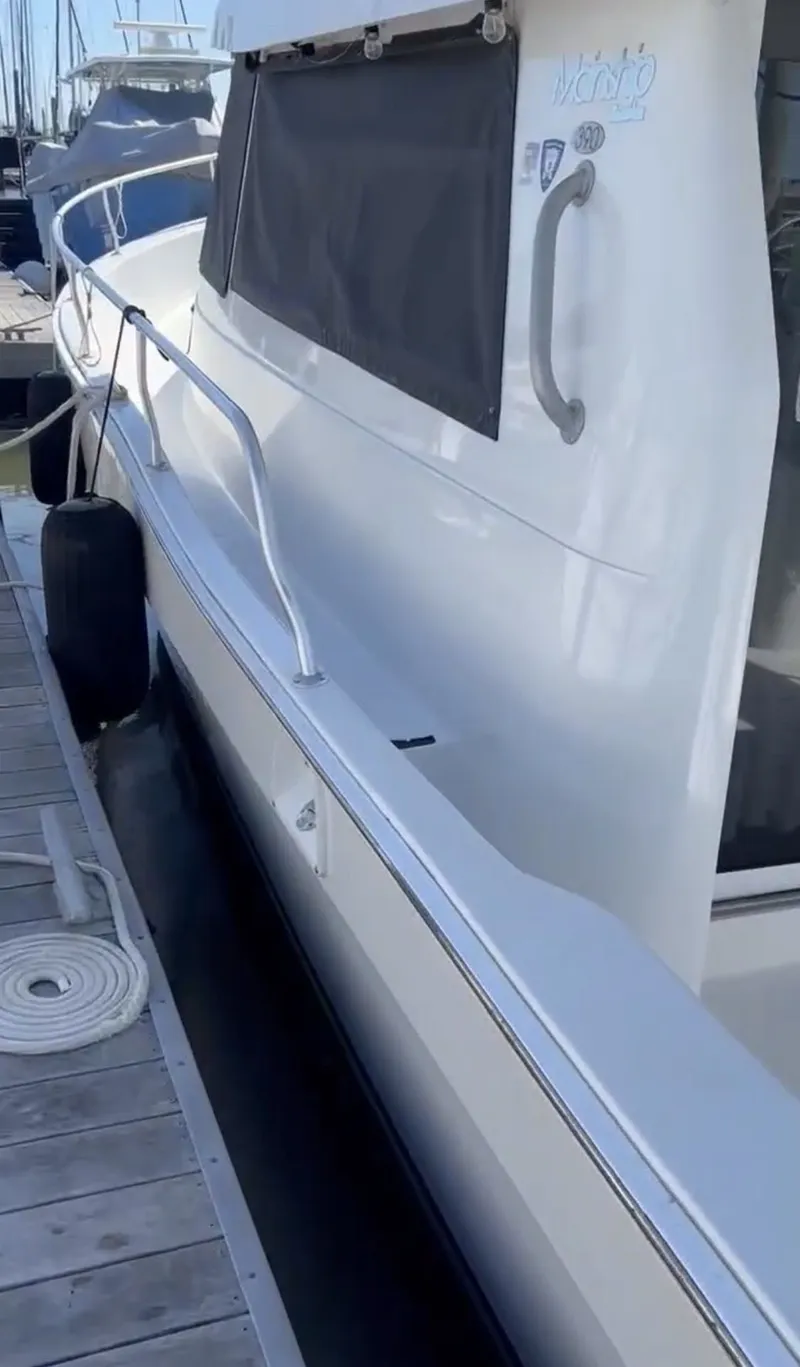 Slide: The Image of 2001 Mainship 390 Trawler docked, side view with fender. - 23