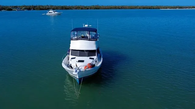 Slide: The Image of 2001 Mainship 390 Trawler anchored on calm waters. - 3
