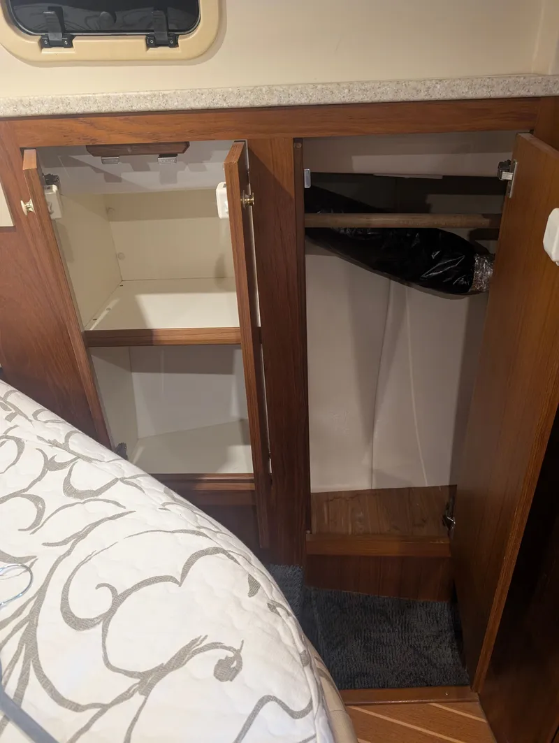 Slide: The Image of Open cabinet inside a 2001 Mainship 390 Trawler. - 34