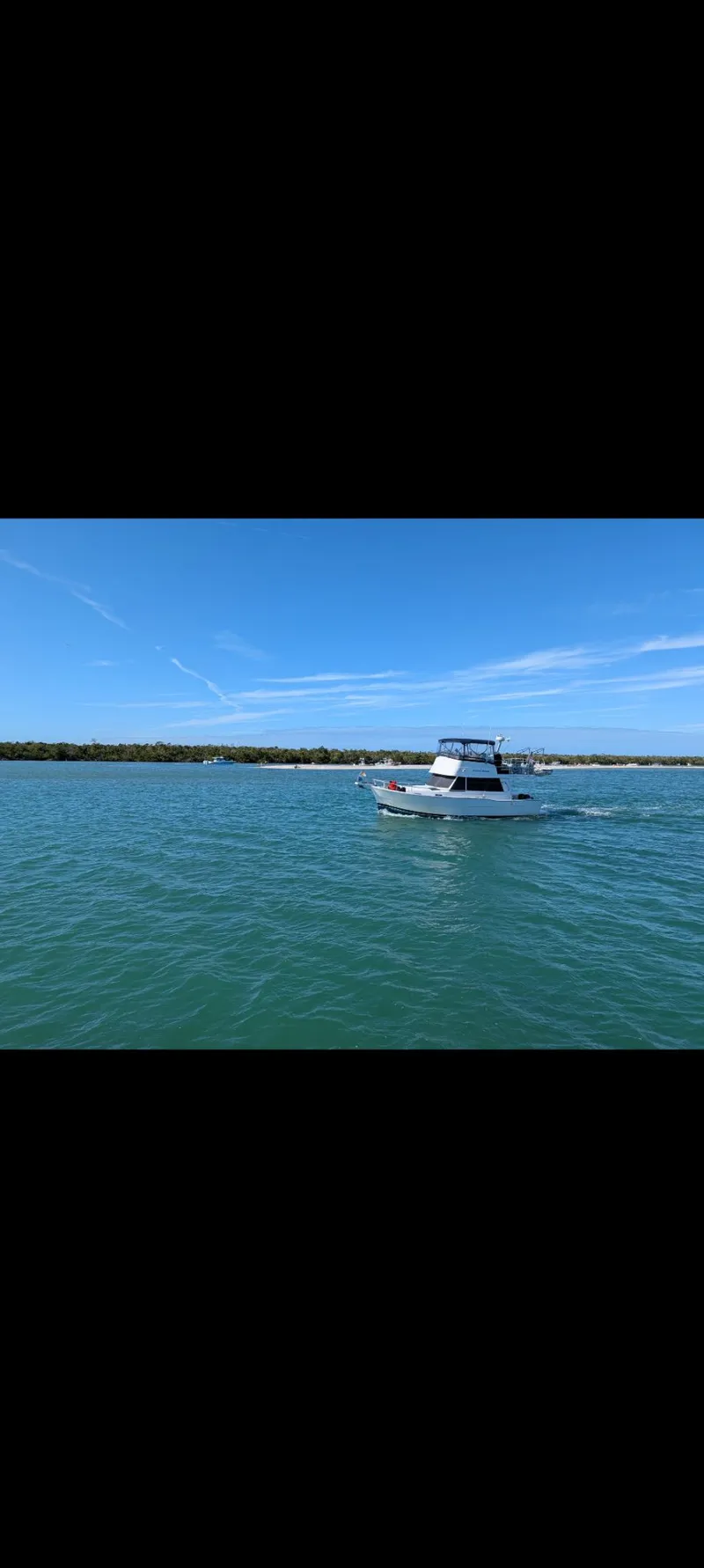 Slide: The Image of 2001 Mainship 390 Trawler on calm waters under blue sky. - 5