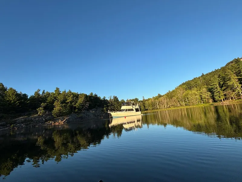 Slide: The Image of 2001 Mainship 390 Trawler on calm lake with wooded shoreline. - 6