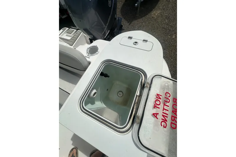 Slide: The Image of 2023 Sea Fox 228 Commander boat with open storage compartment and visible engine. - 23