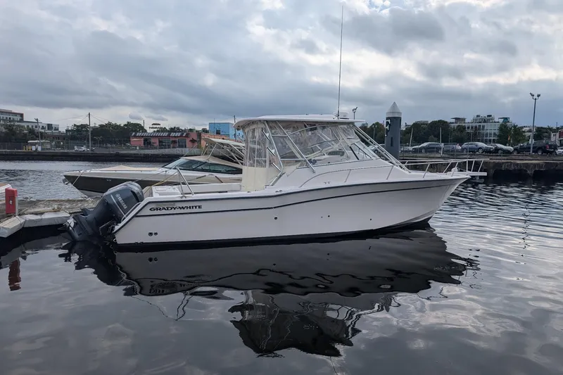 The Image of 2004 Grady-White Express 330 boat docked in a marina under cloudy skies. - 1