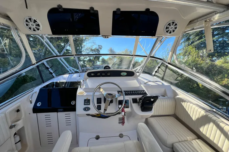 Slide: The Image of 2004 Grady-White Express 330 boat cockpit with steering wheel and seating. - 13