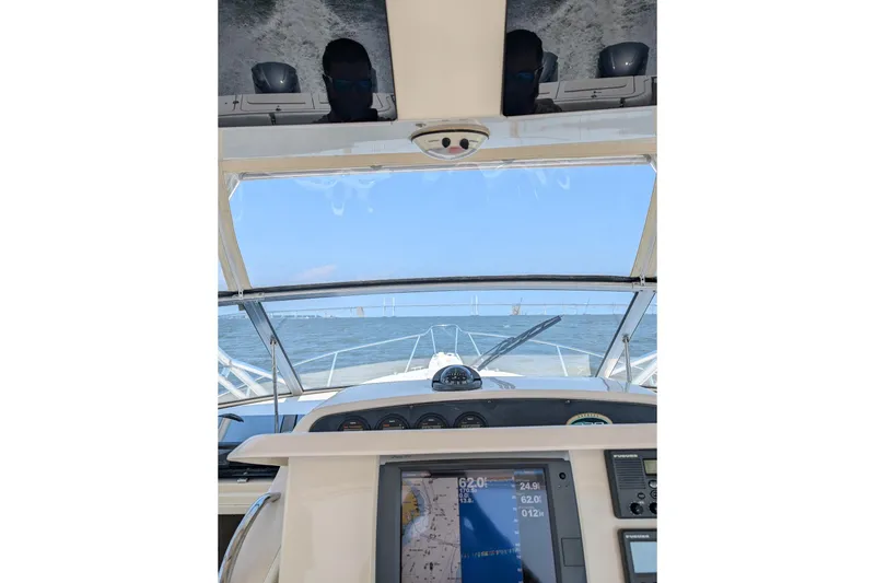 Slide: The Image of 2004 Grady-White Express 330 boat dashboard with navigation screen, cruising on open water. - 15