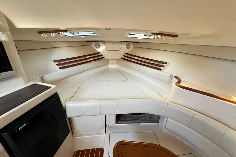 Slide: The Image of Interior cabin of 2004 Grady-White Express 330 boat, featuring white seating and wood accents. - 20