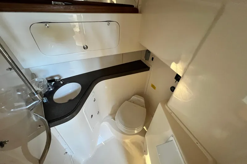 Slide: The Image of 2004 Grady-White Express 330 boat bathroom with sink and toilet, compact and functional design. - 22