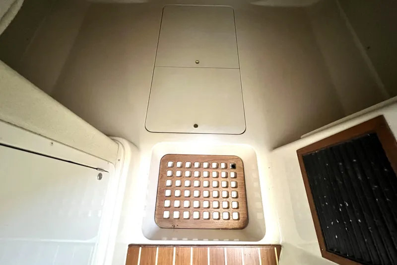 Slide: The Image of 2004 Grady-White Express 330 cabin interior with wooden flooring and storage compartments. - 24