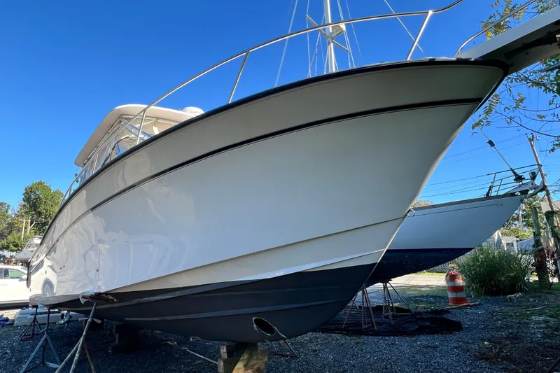 Slide: The Image of 2004 Grady-White Express 330 boat on dry dock under clear blue sky. - 3