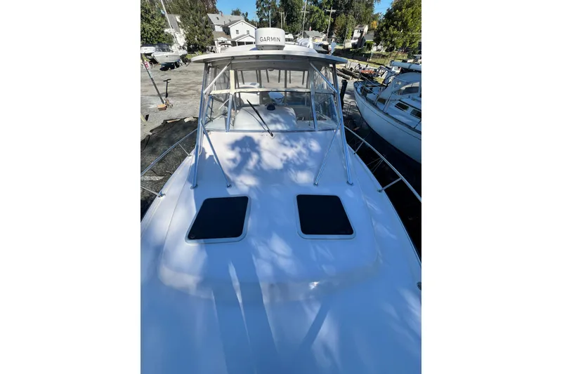Slide: The Image of 2004 Grady-White Express 330 boat docked, featuring Garmin equipment and sleek design. - 31