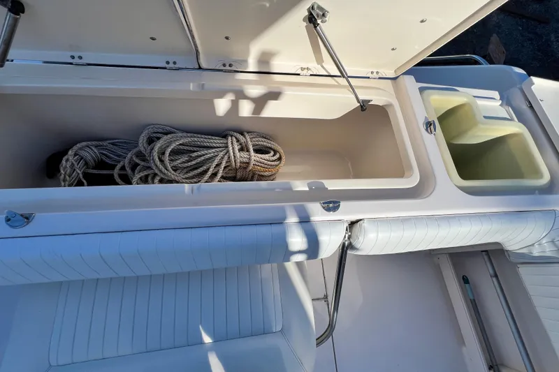 Slide: The Image of Open storage compartment on 2004 Grady-White Express 330 boat with coiled rope inside. - 33