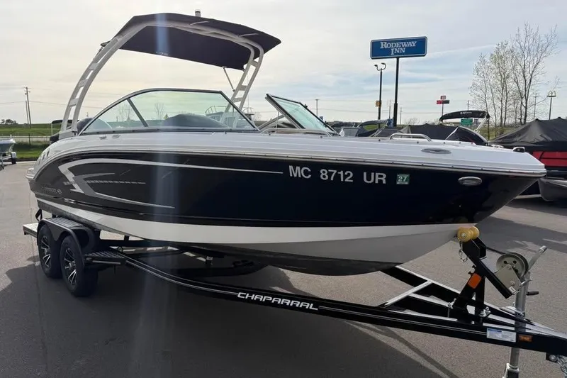 Slide: The Image of 2020 Chaparral 21 SSi OB boat on trailer, parked outdoors near Rodeway Inn. - 2