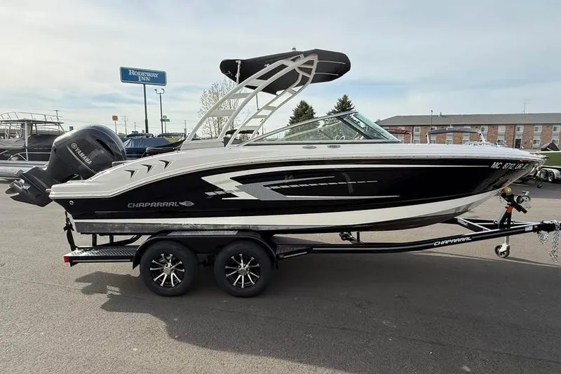 Slide: The Image of 2020 Chaparral 21 SSi OB boat on trailer, black and white design, parked outdoors. - 4