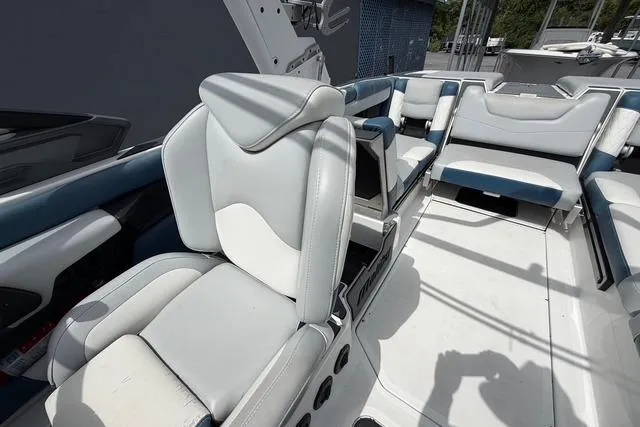 Slide: The Image of 2021 Malibu M240 boat interior with white and blue seating, showcasing luxury design. - 11