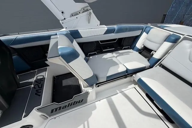Slide: The Image of 2021 Malibu M240 boat interior with white and blue seating. - 12