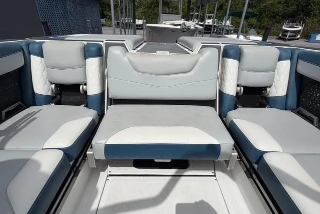 Slide: The Image of 2021 Malibu M240 boat interior with blue and white seating arrangement. - 14