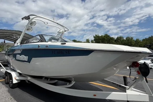 Slide: The Image of 2021 Malibu M240 boat on trailer under cloudy sky. - 5