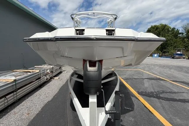 Slide: The Image of 2021 Malibu M240 boat on trailer, parked outdoors under cloudy sky. - 7