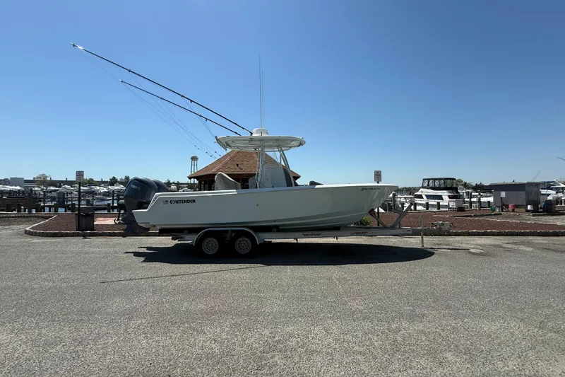 The Image of 2024 Contender 25 Tournament boat on trailer at marina under clear blue sky. - 0