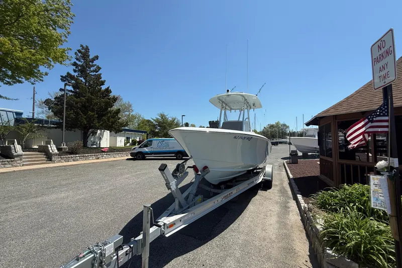 Slide: The Image of 2024 Contender 25 Tournament boat on trailer in sunny marina setting. - 1