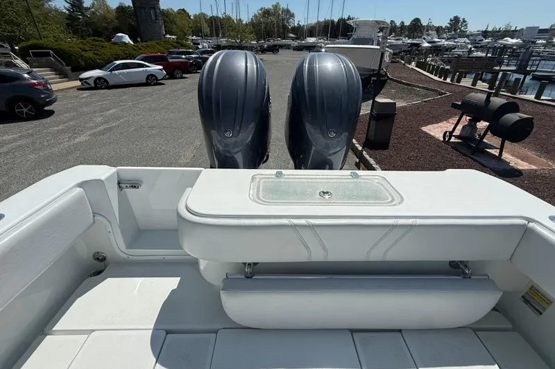 Slide: The Image of 2024 Contender 25 Tournament boat with dual outboard engines at a marina. - 12