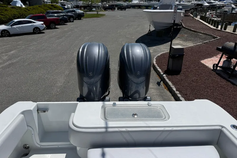 Slide: The Image of 2024 Contender 25 Tournament boat with dual outboard engines in a marina parking area. - 19