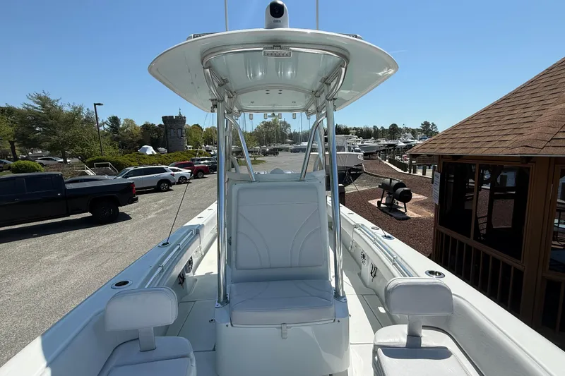Slide: The Image of 2024 Contender 25 Tournament boat with T-top, docked in a marina under clear skies. - 4