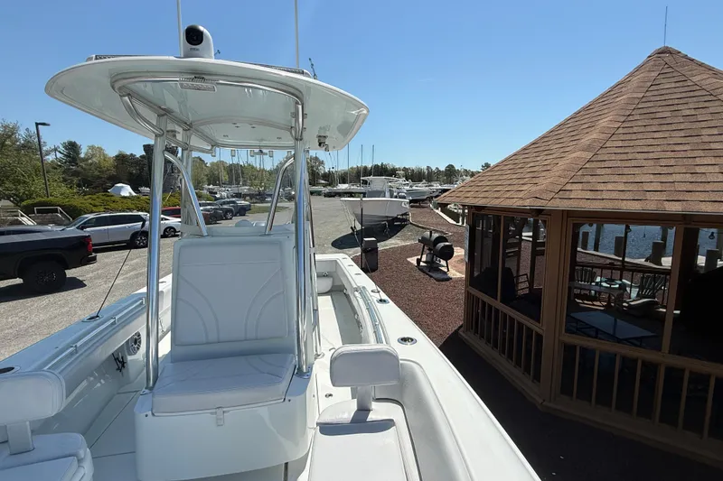 Slide: The Image of 2024 Contender 25 Tournament boat docked near a wooden gazebo on a sunny day. - 5