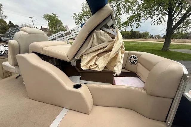 Slide: The Image of 2012 Bennington 2574 GCW pontoon boat interior with beige seating and storage compartment. - 18