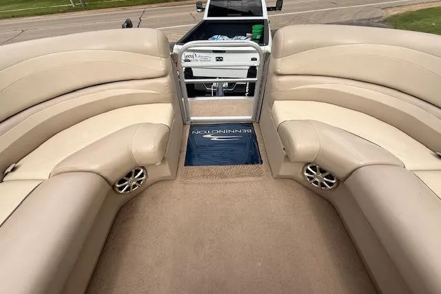 Slide: The Image of 2012 Bennington 2574 GCW boat interior with beige seating and speaker system. - 20