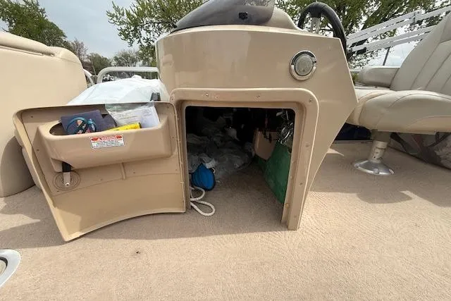 Slide: The Image of 2012 Bennington 2574 GCW boat interior storage compartment with open door, revealing contents. - 21