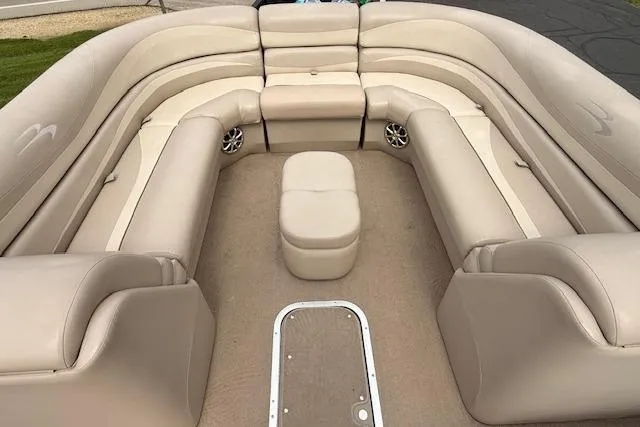 Slide: The Image of 2012 Bennington 2574 GCW boat interior with beige seating and central ottoman. - 22