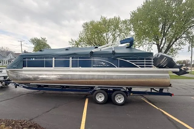 Slide: The Image of 2012 Bennington 2574 GCW pontoon boat on trailer, covered and parked outdoors. - 30