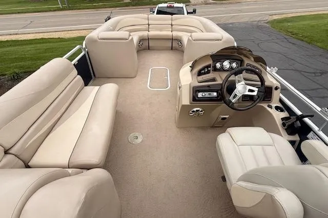 Slide: The Image of 2012 Bennington 2574 GCW pontoon boat interior with beige seating and steering console. - 4
