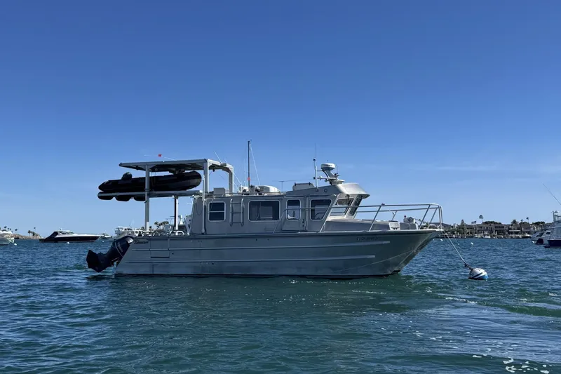 The Image of 2015 Armstrong Marine Power Cat boat anchored on calm water under clear blue sky. - 0