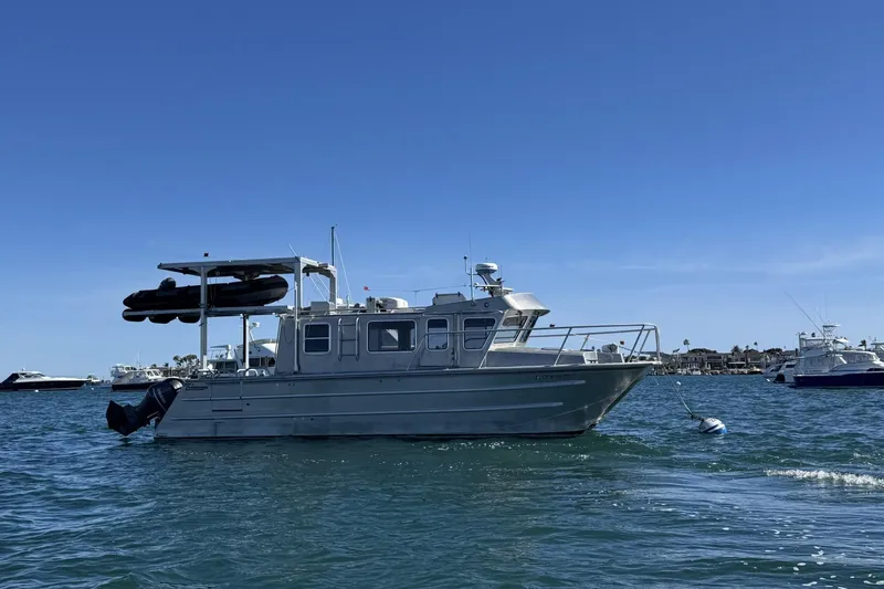 Slide: The Image of 2015 Armstrong Marine Power Cat boat anchored in calm waters under clear blue sky. - 18