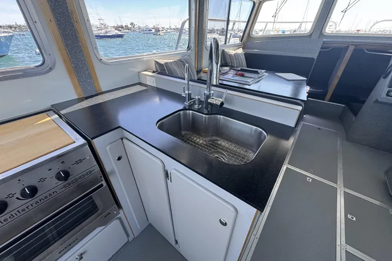Slide: The Image of Interior of 2015 Armstrong Marine Power Cat kitchen with sink and stove, overlooking marina. - 2