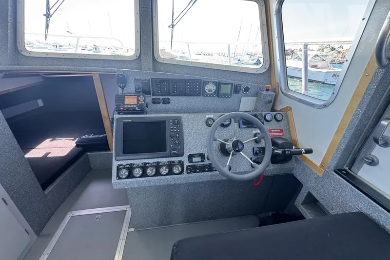Slide: The Image of 2015 Armstrong Marine Power Cat cockpit with steering wheel and navigation equipment. - 3