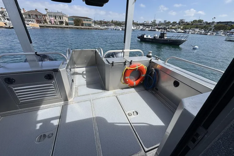 Slide: The Image of 2015 Armstrong Marine Power Cat deck with safety equipment, docked in a marina. - 5