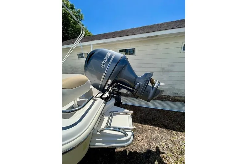 Slide: The Image of 2015 Pioneer 175 Venture boat with Yamaha outboard motor, parked near a white building. - 6