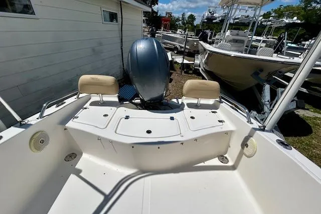 Slide: The Image of 2015 Pioneer 175 Venture boat interior with seating and motor, docked near other boats. - 8