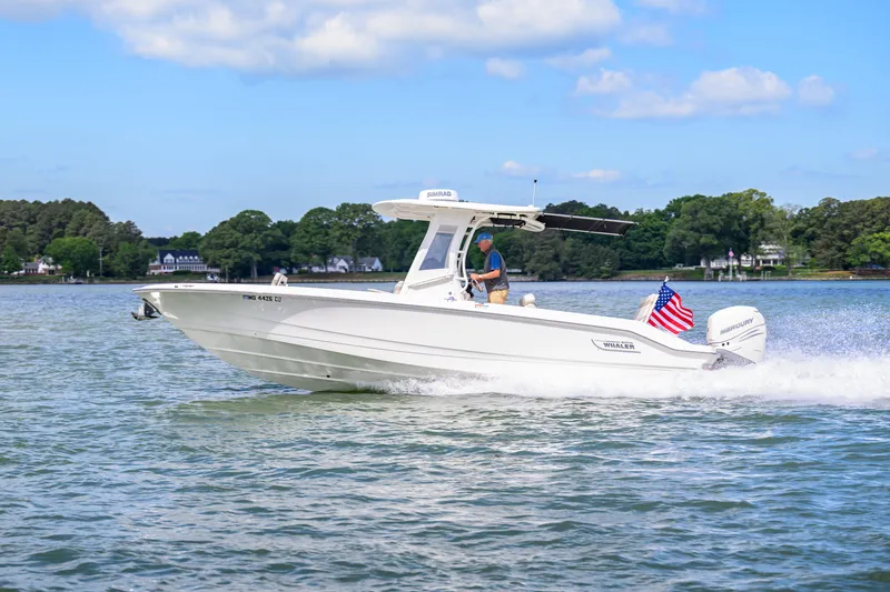The Image of 2023 Boston Whaler 280 Dauntless cruising on a scenic lake with American flag. - 0