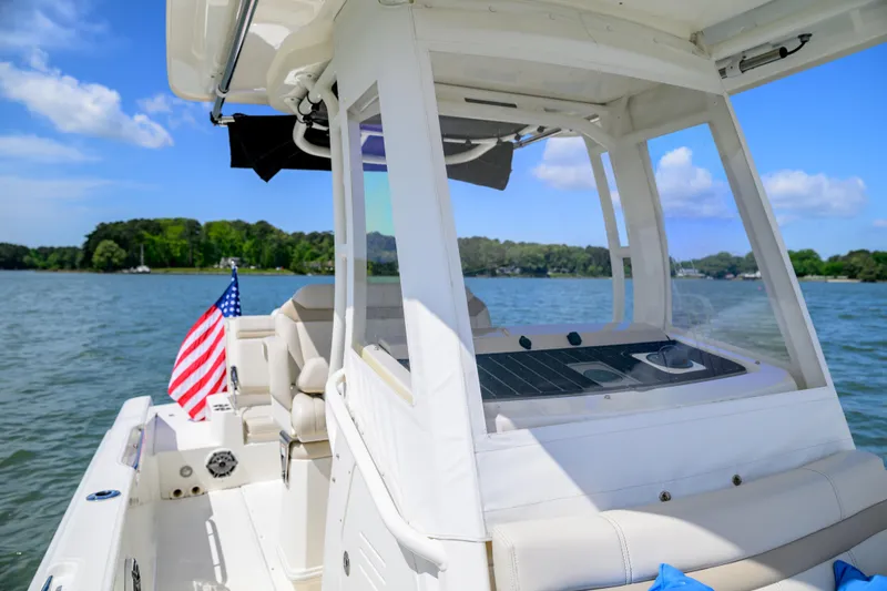 Slide: The Image of 2023 Boston Whaler 280 Dauntless boat on a scenic lake with American flag. - 11