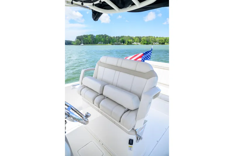 Slide: The Image of 2023 Boston Whaler 280 Dauntless boat interior with plush seating and American flag. - 13