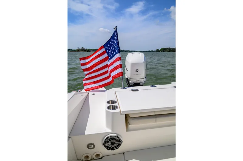 Slide: The Image of Boston Whaler 280 Dauntless 2023 boat with American flag on lake. - 18