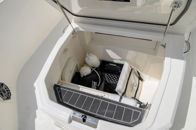 Slide: The Image of Storage compartment of 2023 Boston Whaler 280 Dauntless boat, containing safety equipment and accessories. - 24