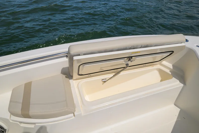 Slide: The Image of 2023 Boston Whaler 280 Dauntless boat seat with storage compartment open, on water. - 28