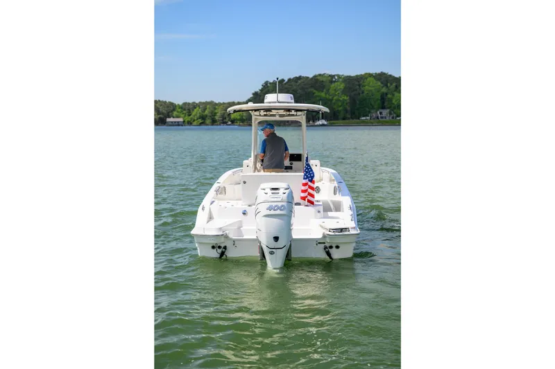 Slide: The Image of 2023 Boston Whaler 280 Dauntless boat on water, rear view with American flag. - 6