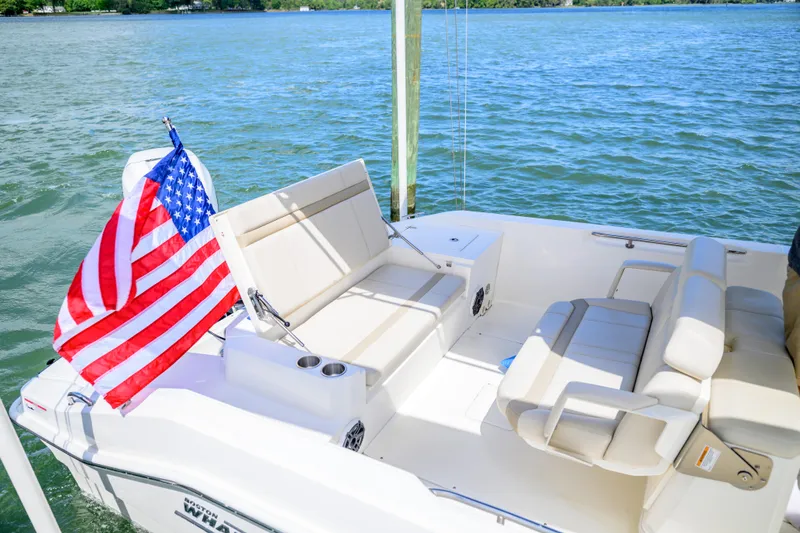 Slide: The Image of 2023 Boston Whaler 280 Dauntless boat with American flag on calm water. - 7