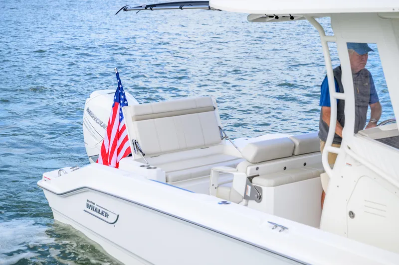 Slide: The Image of 2023 Boston Whaler 280 Dauntless boat on water, featuring American flag and Mercury engine. - 8
